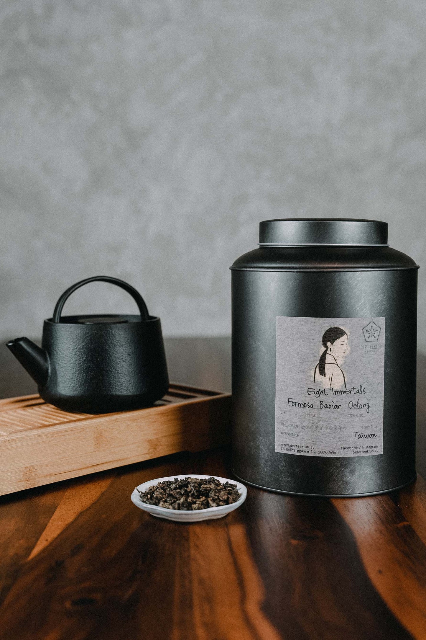 gerollter Oolongtee neben großer Urne