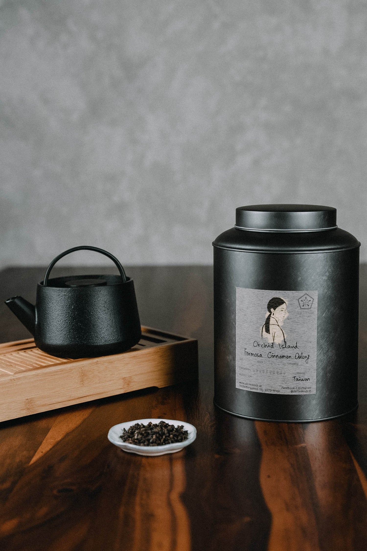 Orchid Island Oolongtee neben Kanne und Dose auf schönem Holztisch